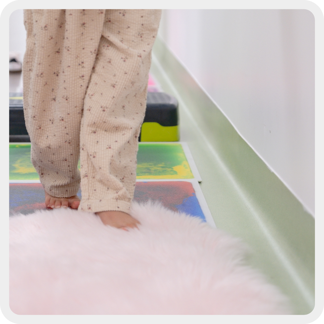 Ai bambini, spesso, come esperienza sensoriale, viene creato un percorso da fare a piedi nudi per sentire al tatto varie superficii. In questo scatto due piedini si muovono su un tappeto peloso 