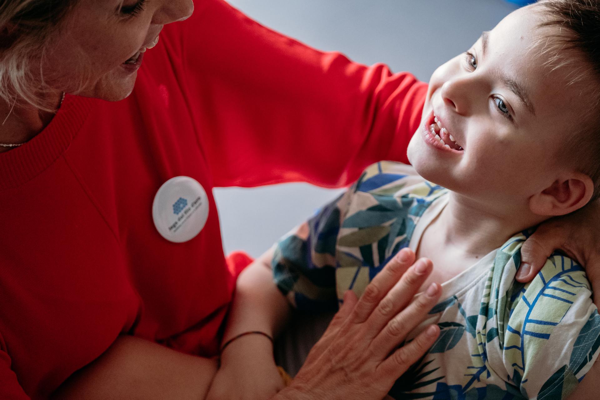 Edoardo, una bimbo utente della Lega del Filo d'Oro, con un educatrice 