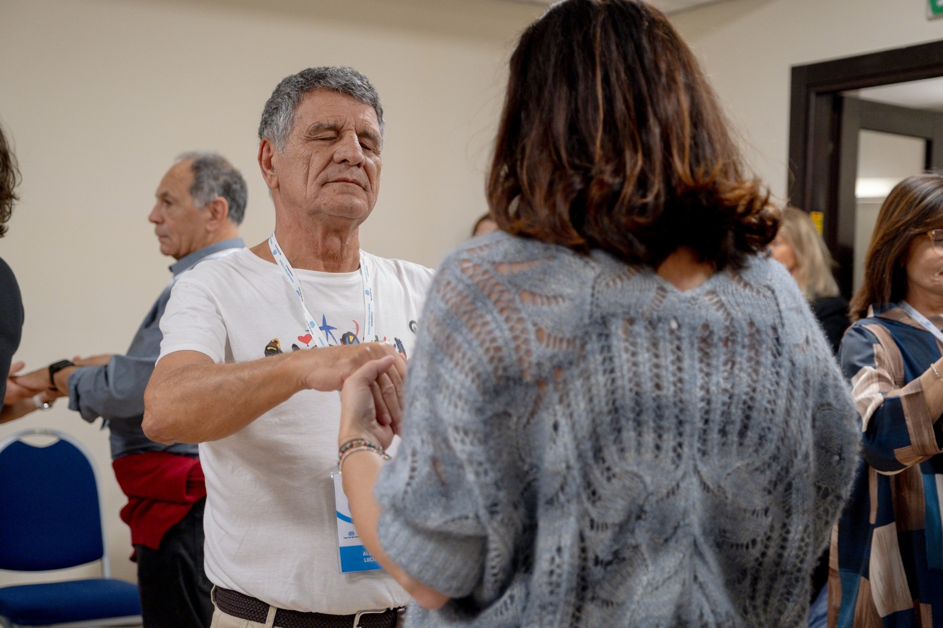 Durante il laboratorio di musica del Forum dei Volontari, due partecipanti si tengono per mano mentre vivono l’esperienza con coinvolgimento emotivo. Una delle due persone ha gli occhi chiusi, in un momento di ascolto, relazione e condivisione.