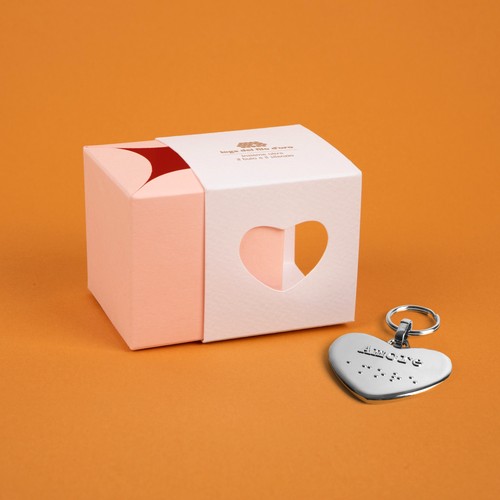 Bomboniera composta da due scatoline in cartoncino pregiato inserite l'una nell'altra. Quella esterna è bianca, quella interna, visibile da un'apertura a forma di cuore, è rosa. Accompagnata dal suo portachiavi cuore 39