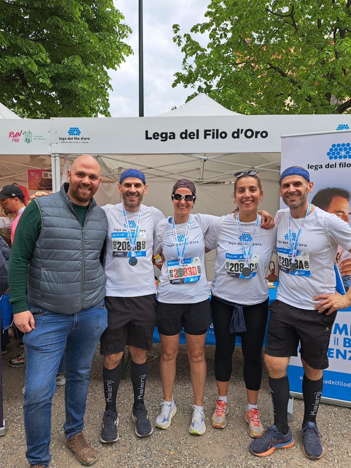 Uno dei team della Lega del Filo d'Oro alla Milano Marathon 2026 in posa davanti allo stand presente