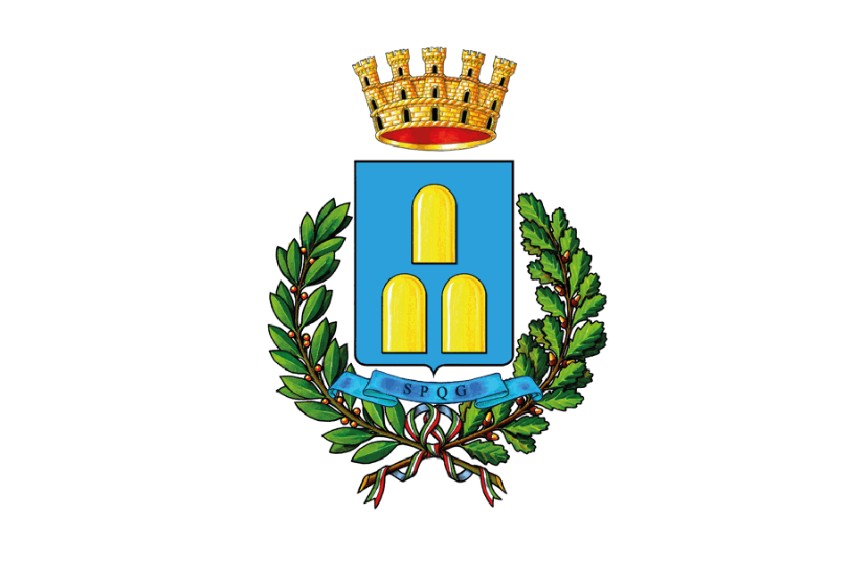 L'immagine mostra lo stemma del Comune di Zagarolo su sfondo bianco. Al centro si trova uno scudo azzurro con tre monti stilizzati dorati. Sopra lo scudo c'è una corona muraria dorata, mentre ai lati e sotto è avvolto da un ramo di alloro e uno di quercia legati da un nastro azzurro con la sigla "SPQG".