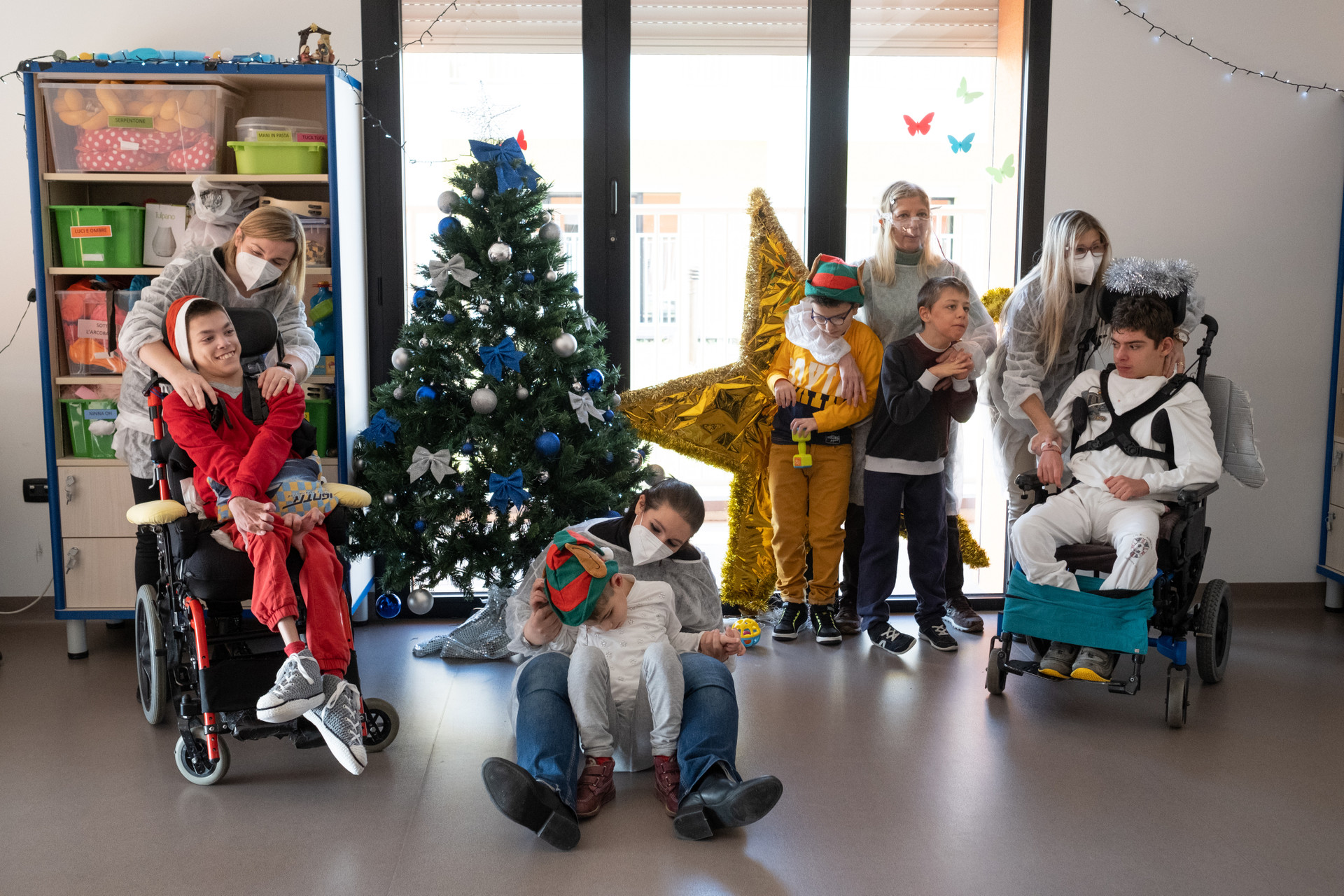 Bambini, ragazzi sordociechi ed operatrici in clima di festa per il Natale, con addobbi, cappelli e decorazioni colorate. 