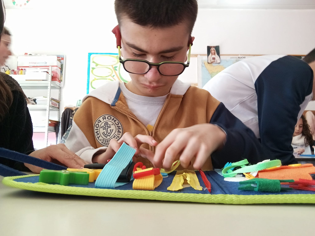 Biagio Luigi, utente seguito dalla Sede Territoriale di Termini Imerese, mentre è a scuola e fa attività con giochi tattili.