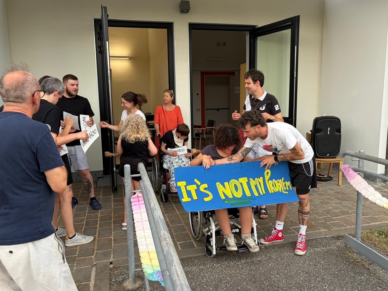 Sara, utente della Lega del Filo d'Oro di Lesmo con un cartellone con scritto "it's not my problem"