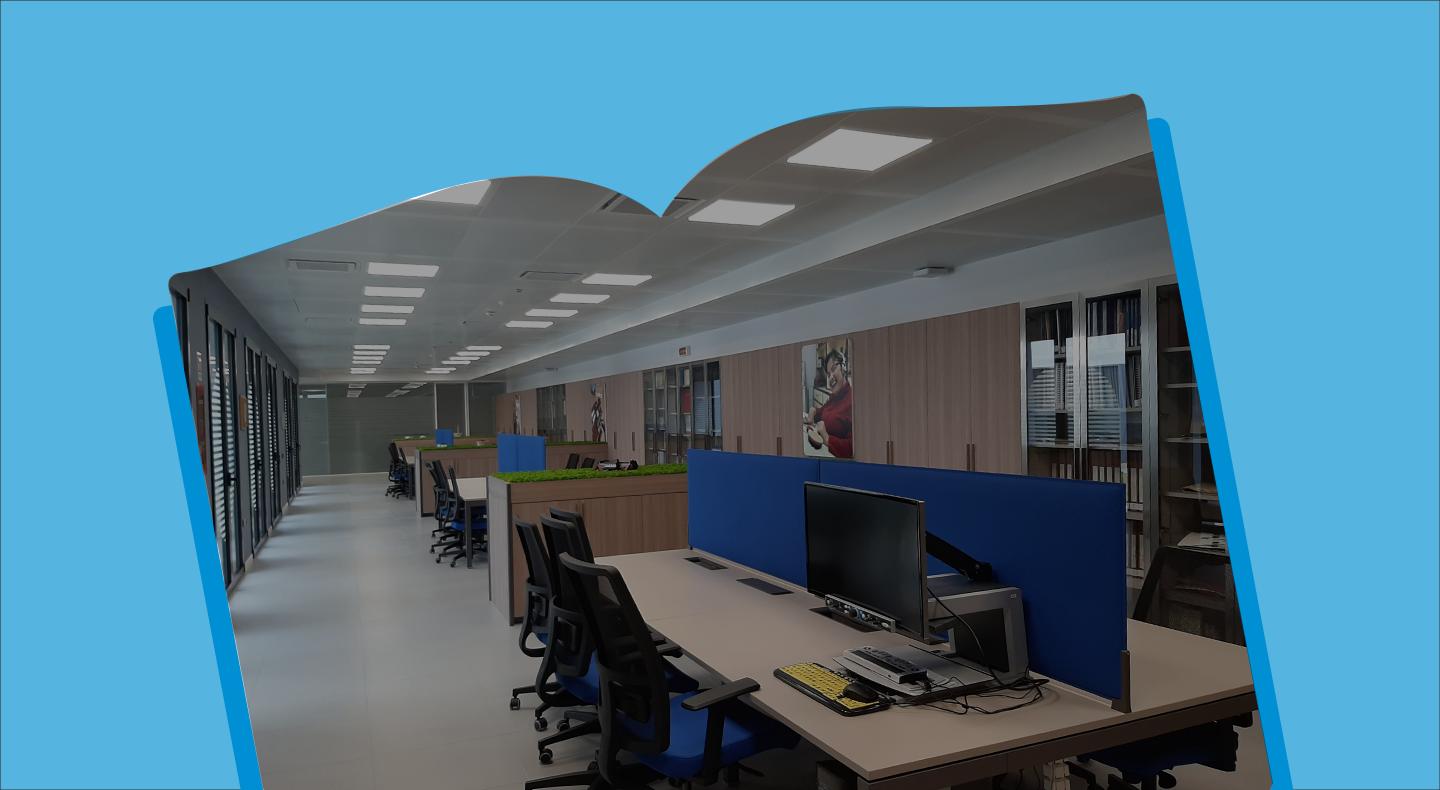 Foto panoramica dell'interno della Biblioteca del Centro Residenziale di Osimo, l'immagine e all'interno di una cornice a forma di libro azzurra.