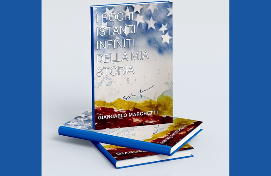 Copertina del libro 'I pochi istanti infiniti della mia storia' di Giancarlo Marchetti, con sfondo astratto e stelle bianche in alto. Due copie del libro sono appoggiate su una superficie chiara.
