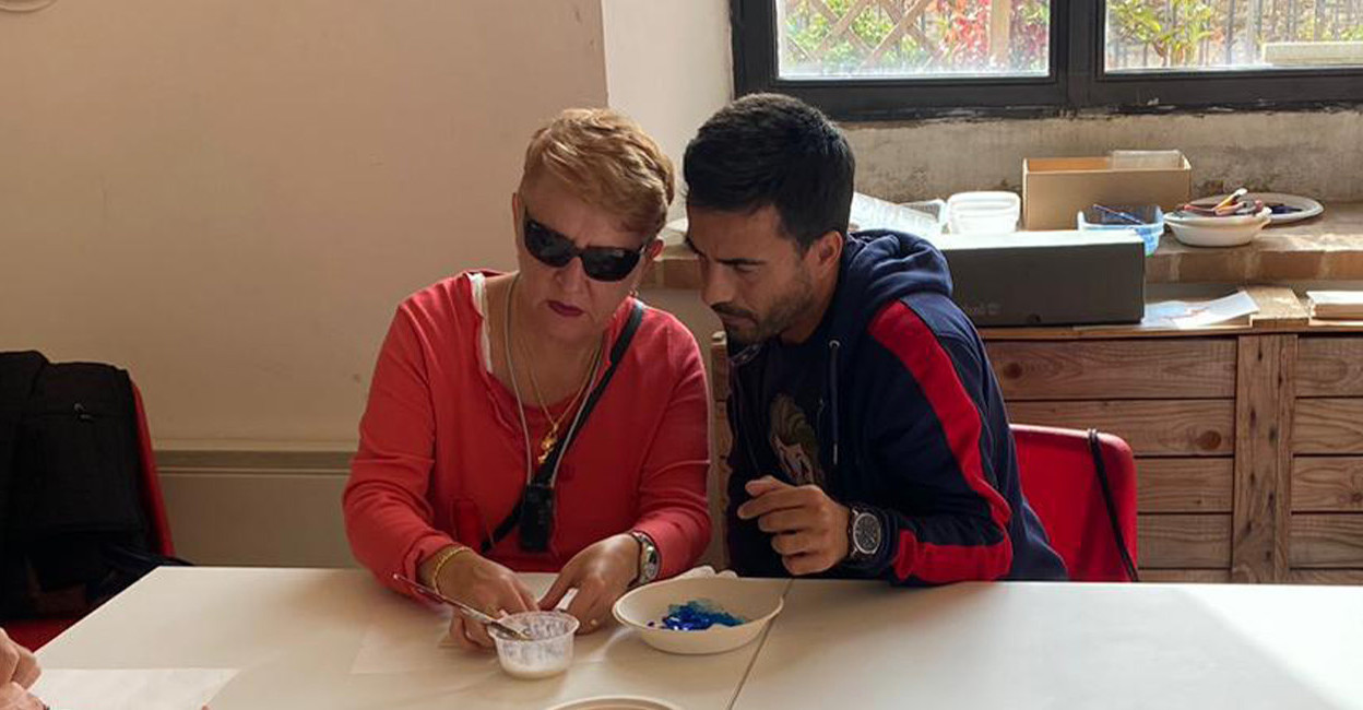 Alessandro, volontario alla Sede della Lega del Filo d'Oro di Pisa, insieme a Cristina, persona sordocieca, mentre fanno laboratorio di pittura