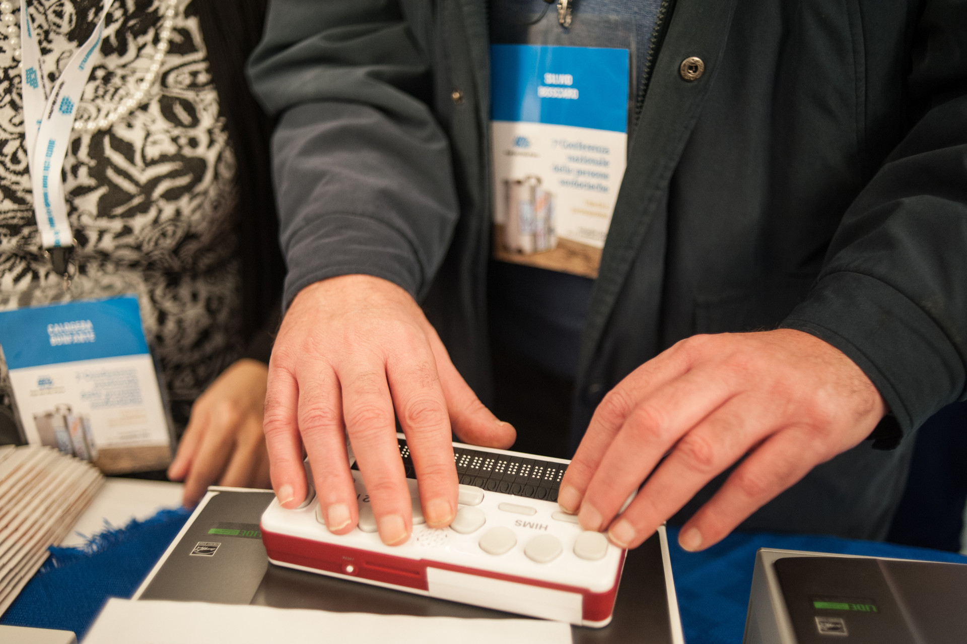 Dettaglio di mani che digitano su una barra Braille, uno degli ausili tecnologici usati dalle persone sordocieche