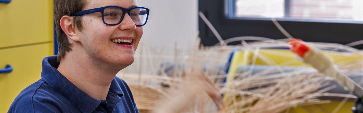 Victor si diverte molto mentre si esercita a realizzare cesti con il midollino nel laboratorio della Lega del Filo d'Oro