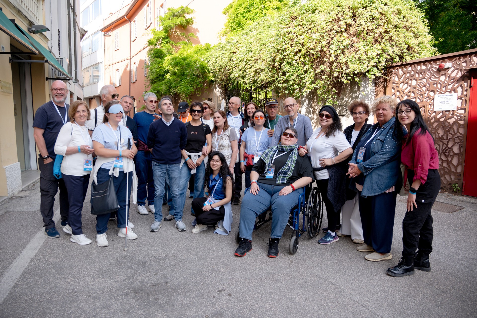 Un gruppo di persone - utenti, dipendenti, volontari e interpreti - in visita al Laboratorio Mosaico, a Ravenna