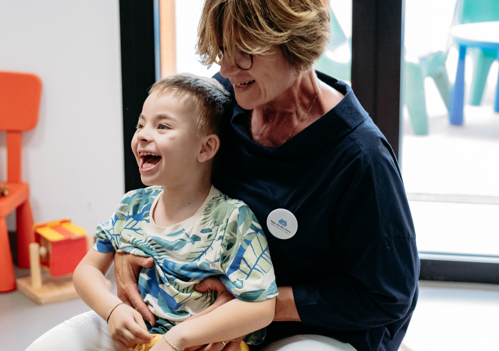 Edoardo un utente della Lega del Filo d'Oro, con la usa opertrice sorridente