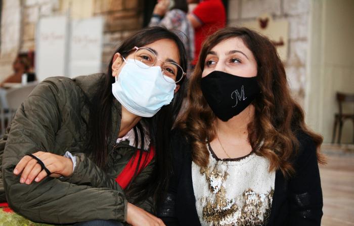 Giovane utente lfo, con un volontario. Le due ragazze posano sedute l'una accanto all'altra indossando le mascherine ffp2