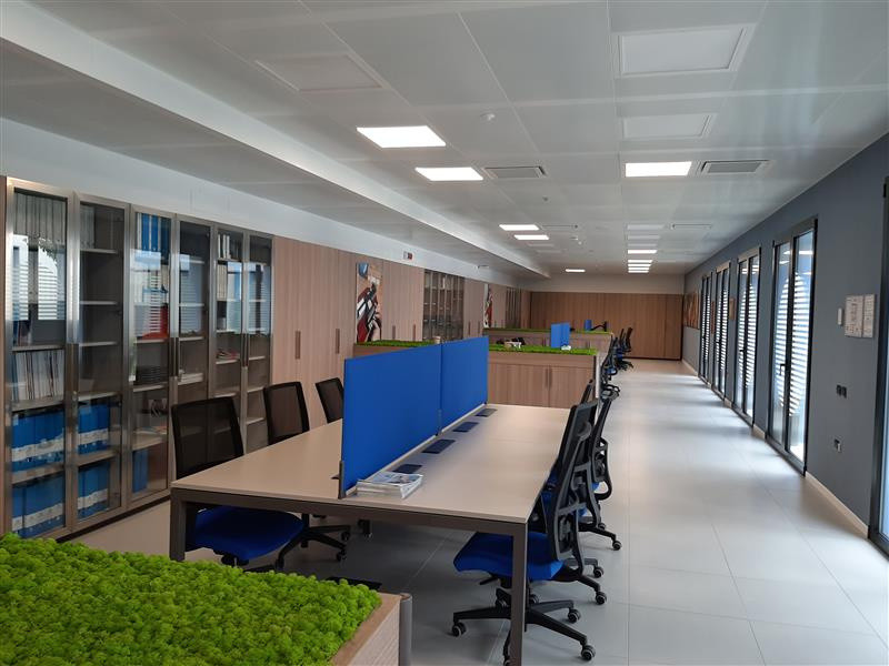 Panoramica della Biblioteca del Centro Nazionale di Osimo con un taglio semi laterale illuminata da luce naturale proveniente dalle vetrate presenti su tutto il lato destro