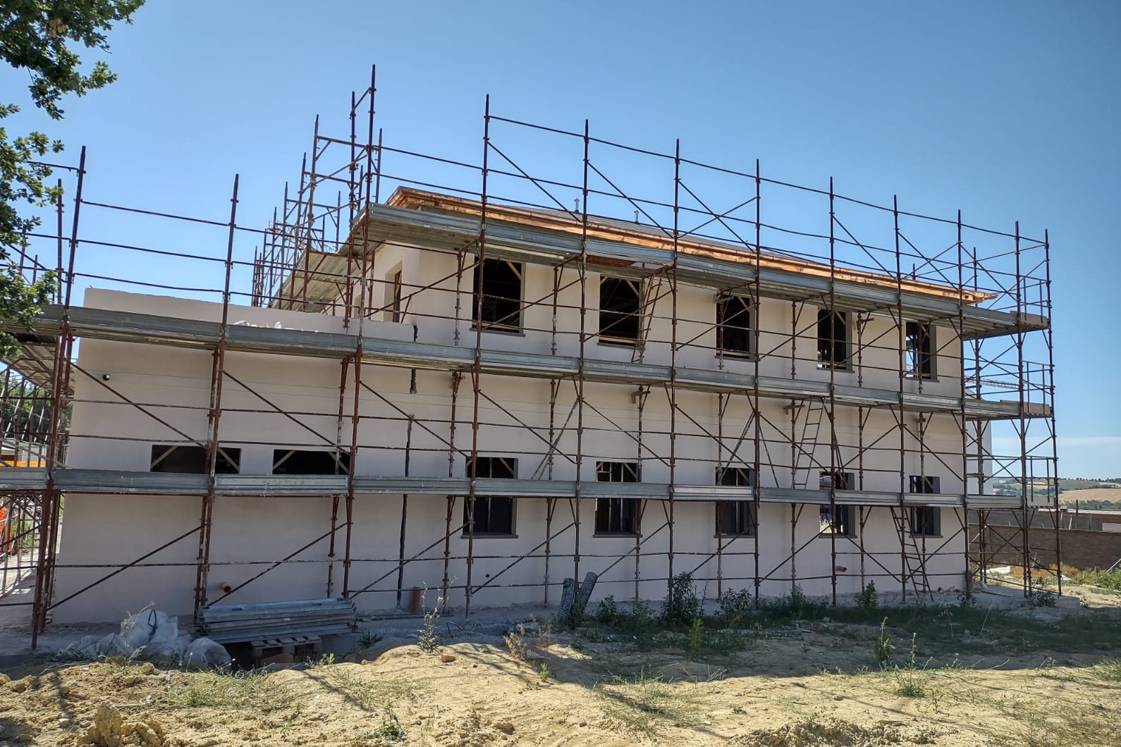 La casa colonica in fase di ristrutturazione, con le impalcature e la terra intorno.