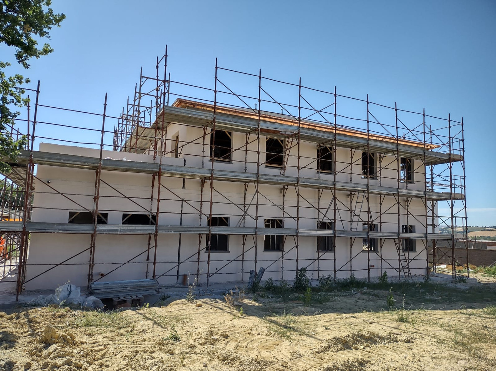 La casa colonica in fase di ristrutturazione, con le impalcature e la terra intorno.