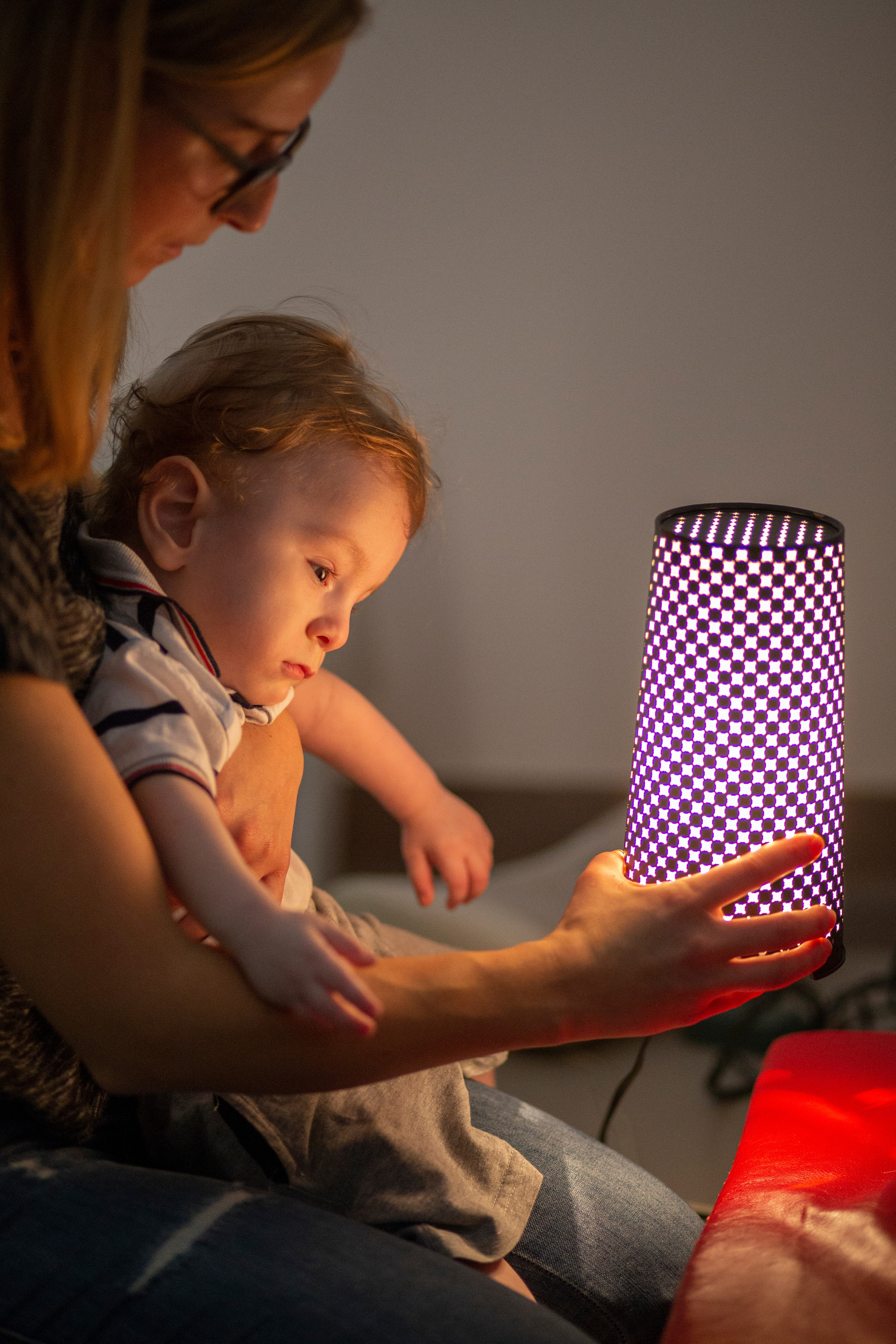 Stimolazione dei residui visivi: il piccolo Gabriele in braccio all'educatrice guarda affascinato la luce di una lampada che lei gli sta mostrando