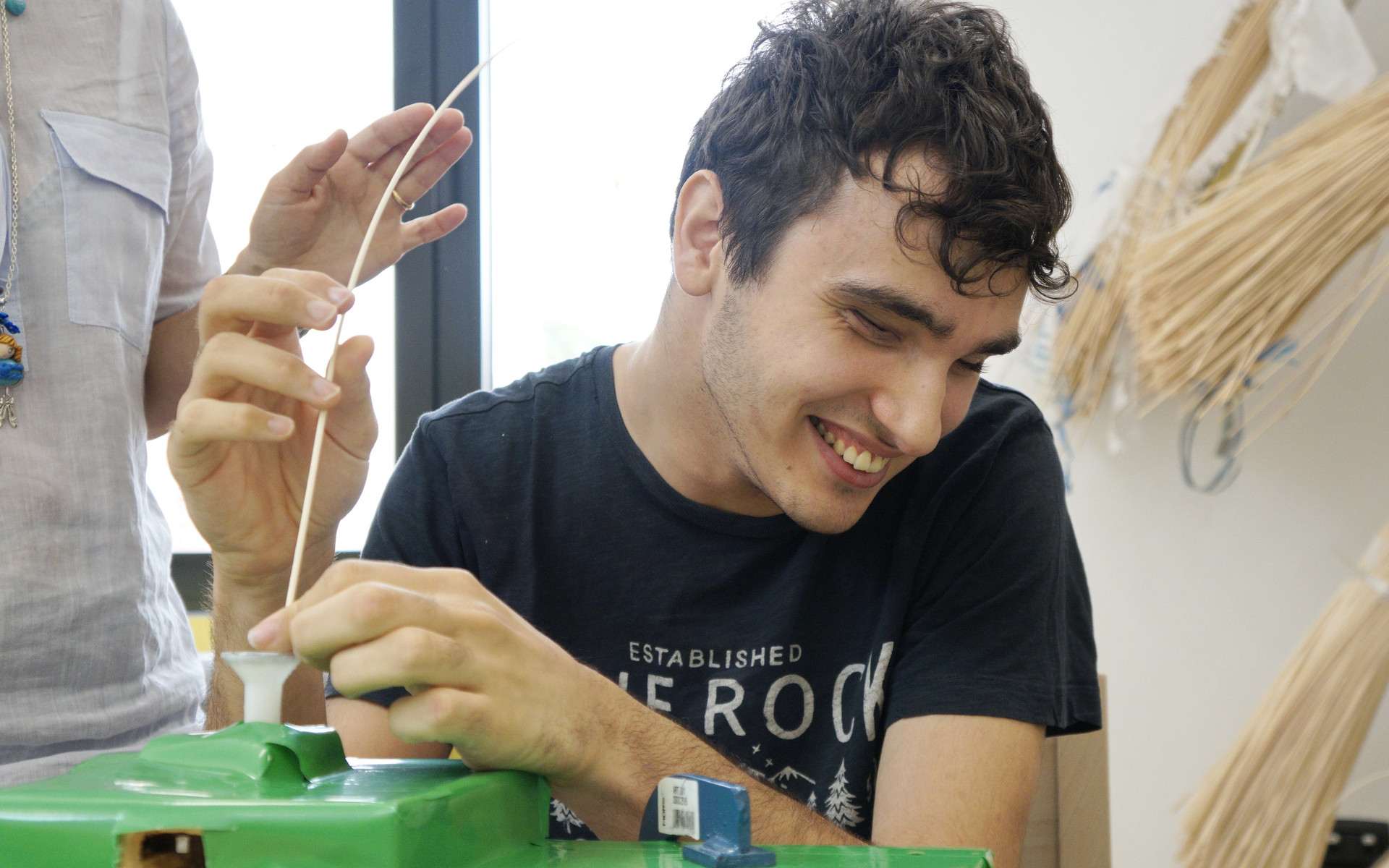 Francesco, giovane utente seguito al Centro Diurno di Osimo, si diverte a lavorare il midollino in laboratorio
