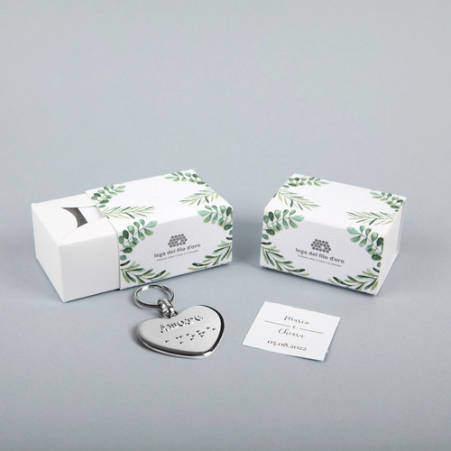 Still life su sfondo grigio della bomboniera green accompagnata dal suo portachiavi cuore e bigliettino personalizzato 50