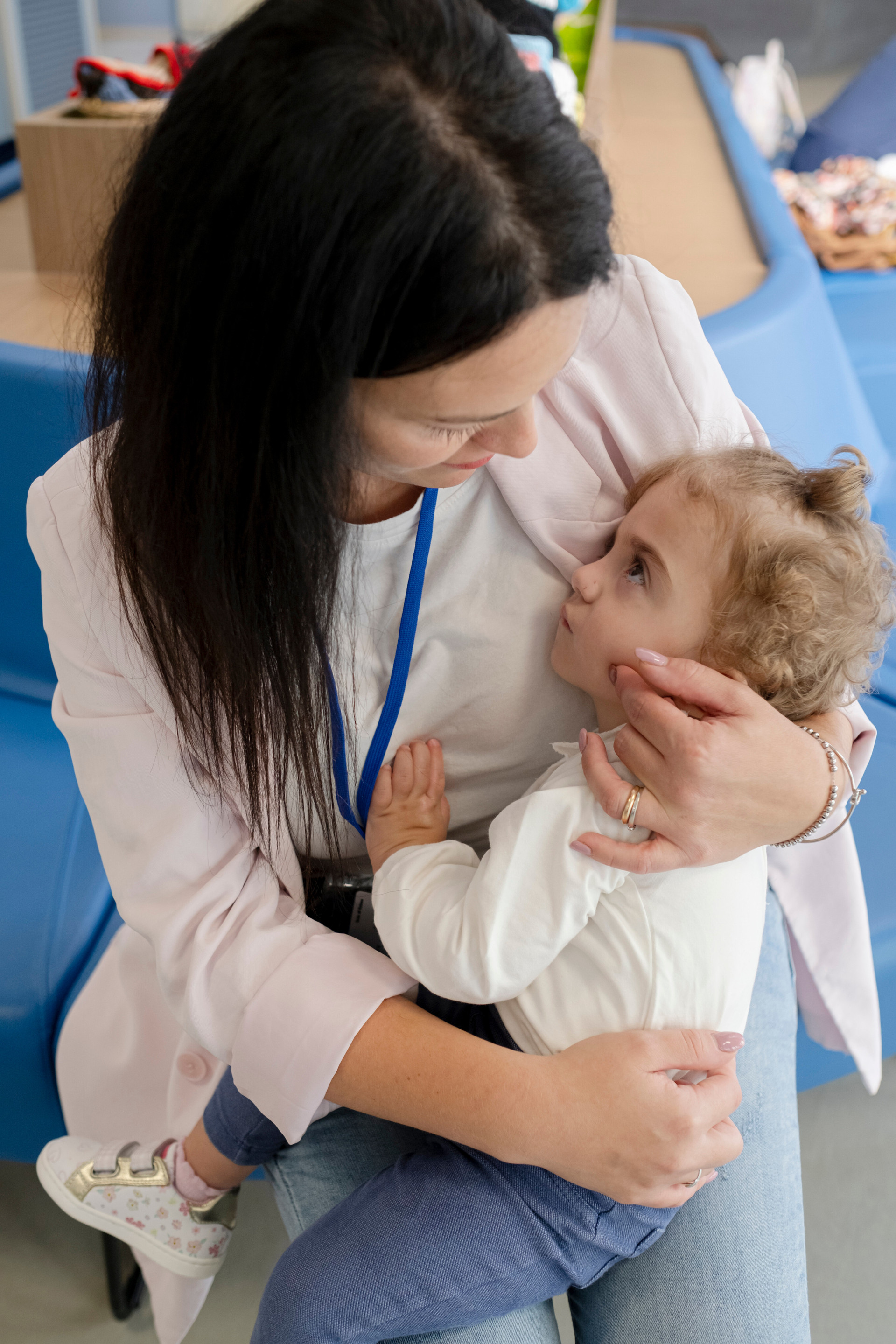 La piccola Benedetta, in braccio a sua mamma Agostina, in un bellissimo abbraccio d'amore sedute nel divanetto dell'ingresso del Centro Nazionale a Osimo