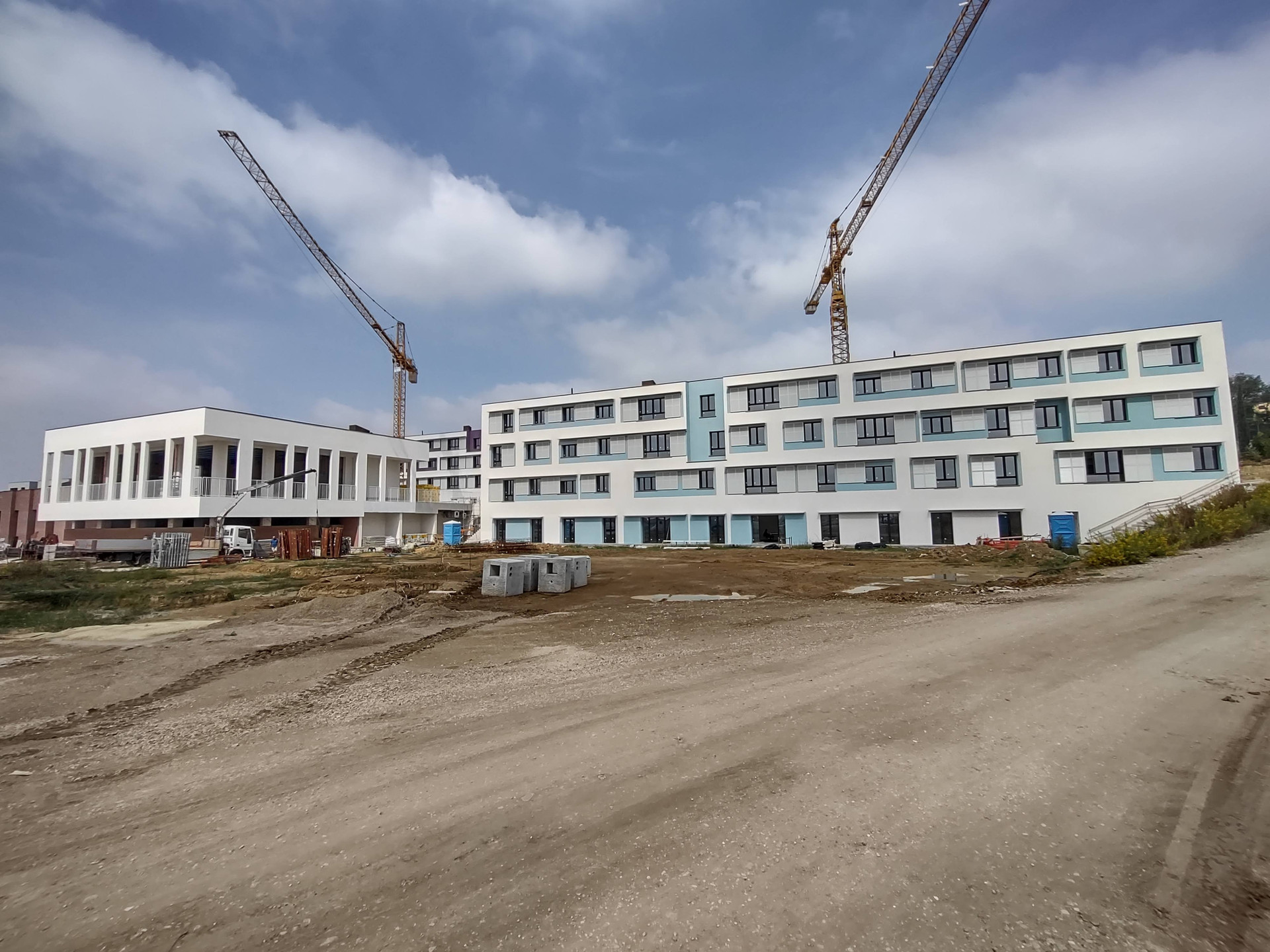 Cantiere del Secondo Lotto del Centro Nazionale di Osimo. Veduta esterna di due edifici in fases di ultimazioni. Presenti anche due gru.