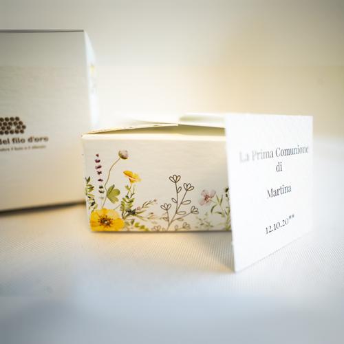 Bomboniera Floreale Lega del Filo d'Oro, in cartoncino bianco con una fantasia a fiori di campo e una romantica chiusura a cuore. Accompagnata da bigliettino personalizzabile 25