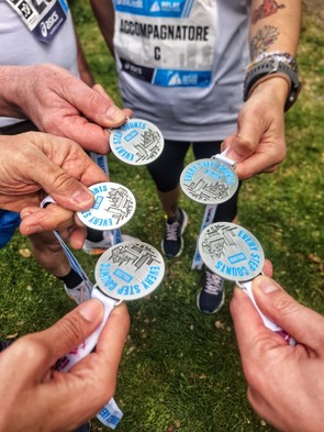 medaglie unicredit relay marathon mostrate con le mani con un prato come sfondo 
