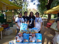 Quattro giovani volontarie pronte ad accogliere i visitatori nellqa loro bancarella di prodotti solidali, Pasta della Bontà, per la Lega del Filo d'Oro