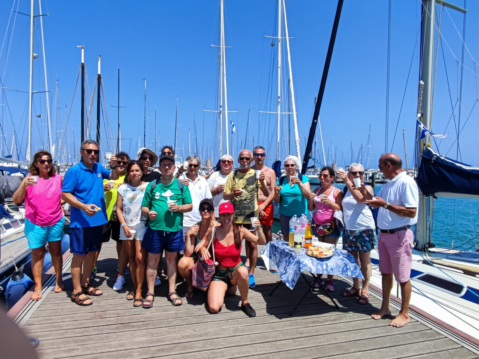 Un gruppo di utenti adulti e accompagnatori sono sul molo a Rimini dopo un'esperienza in barca
