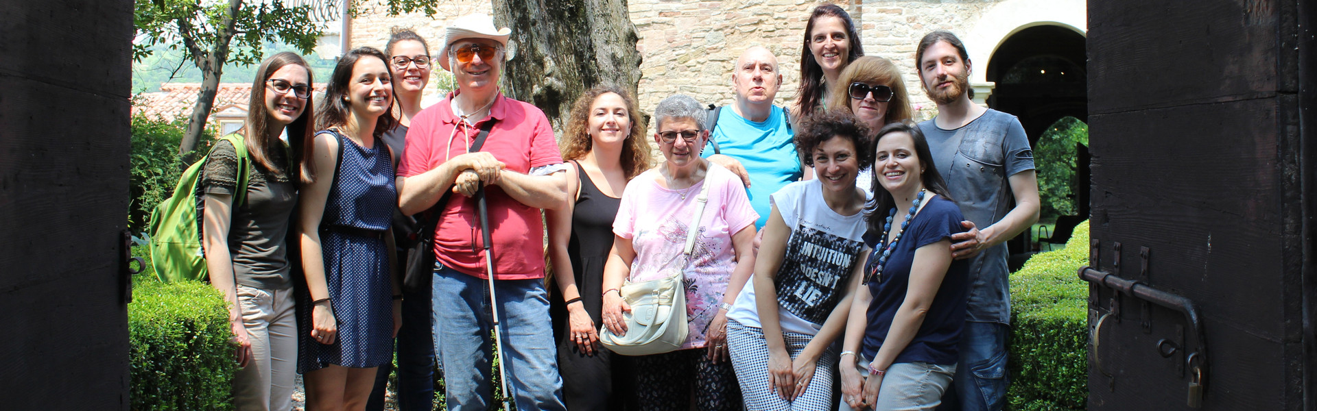 Foto di gruppo di utenti, volontari e parsonale della Sede di Padova in uscita. Alle loro spalle un palazzo antico 