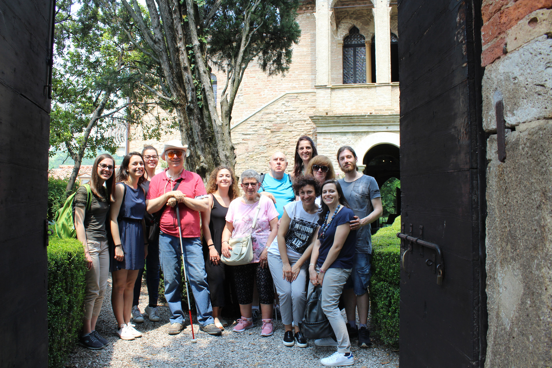 Foto di gruppo di utenti, volontari e parsonale della Sede di Padova in uscita. Alle loro spalle un palazzo antico 
