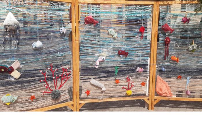 Yarn bombing a Modena con un progetto a tema marino dove si vedono coralli e pesci realizzati all'uncinetto