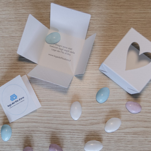 Bomboniera Cubo Pop aperta per mostrare le parti di cui si compone e la scritta interna che spiega la scelta di ispirarsi per le fantasie ai disagni degli ospiti della Lega del Filo d'Oro 12