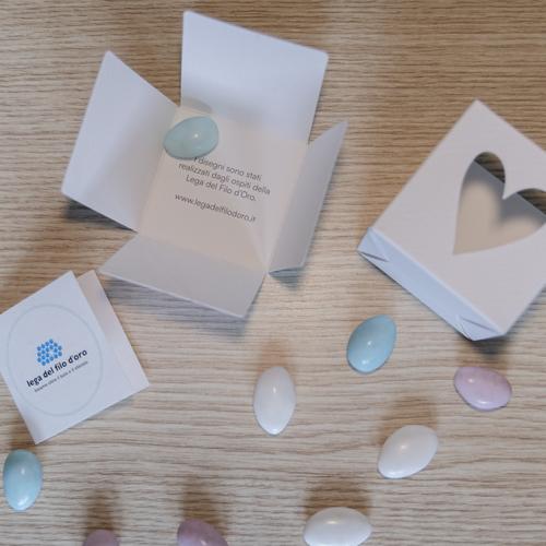 Bomboniera Cubo Pop aperta per mostrare le parti di cui si compone e la scritta interna che spiega la scelta di ispirarsi per le fantasie ai disagni degli ospiti della Lega del Filo d'Oro 16