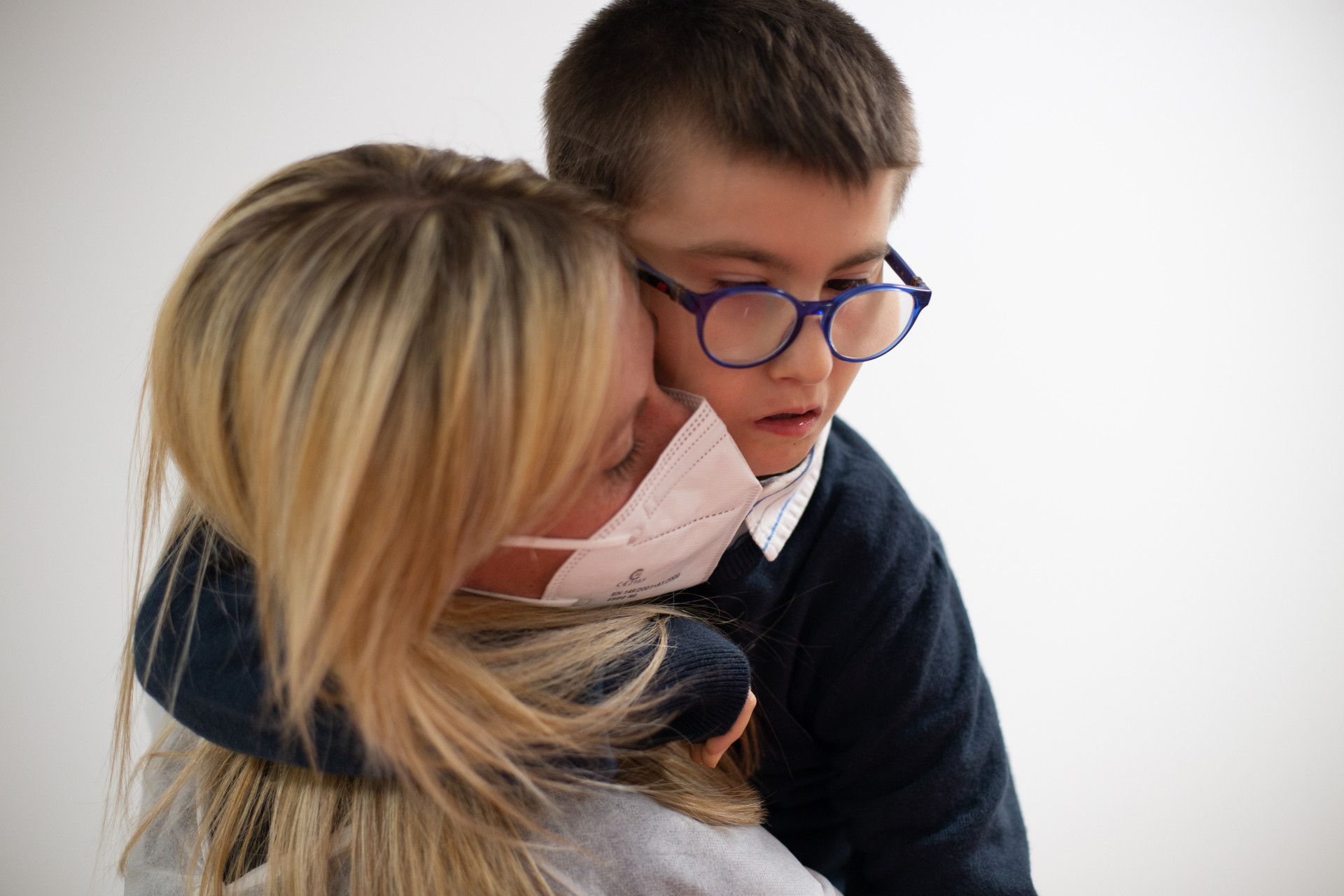 Biagio Luigi, bambino ospite del Centro di Osimo, è in braccio alla sua educatrice che indossa mascherina ffp2 e camice monouso anti covid