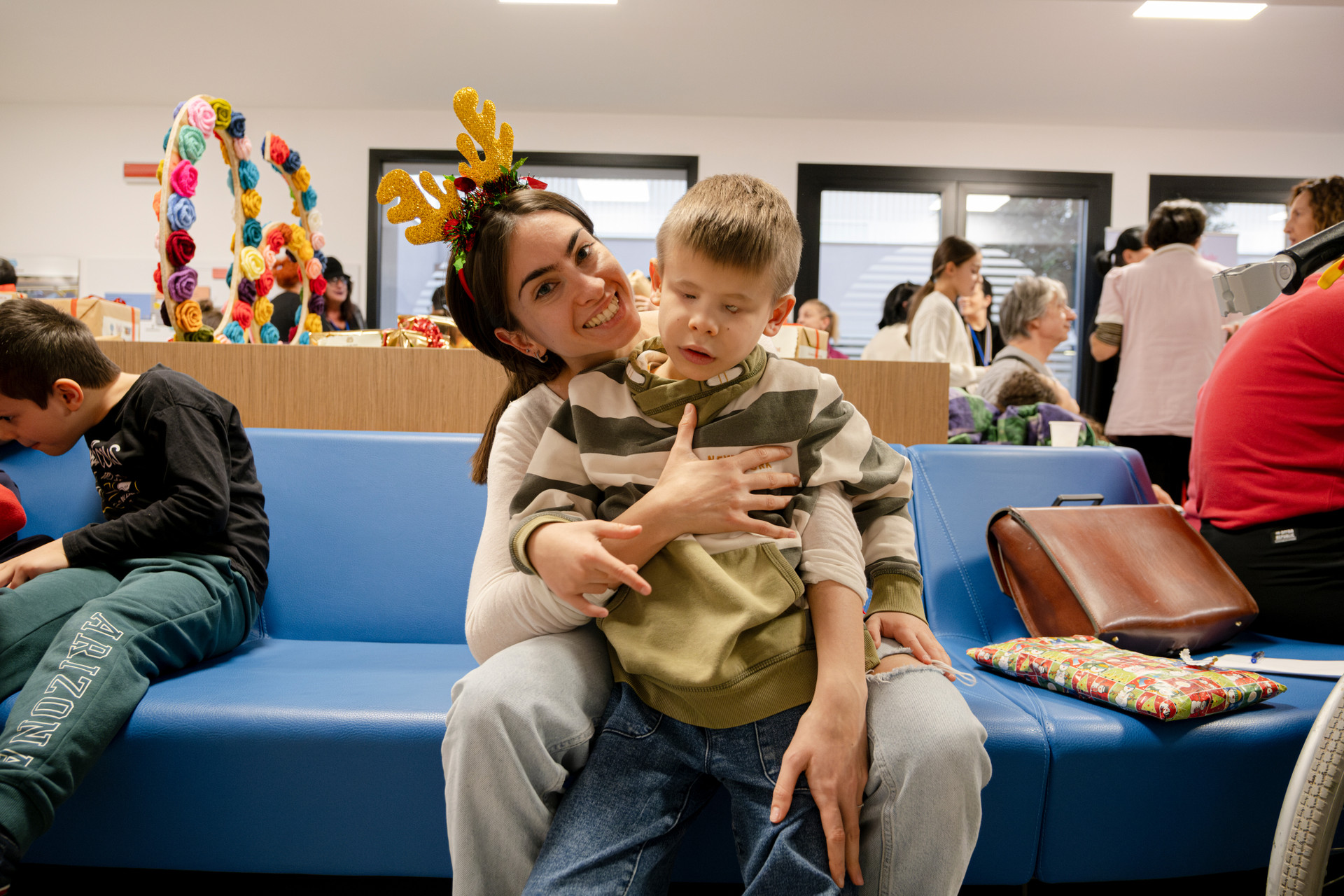 Matteo, bambino utente seguito dalla Lega del Filo d'Oro, insieme alla sua educatrice per una foto insieme prima che inizi lo spettacolo di Natale.