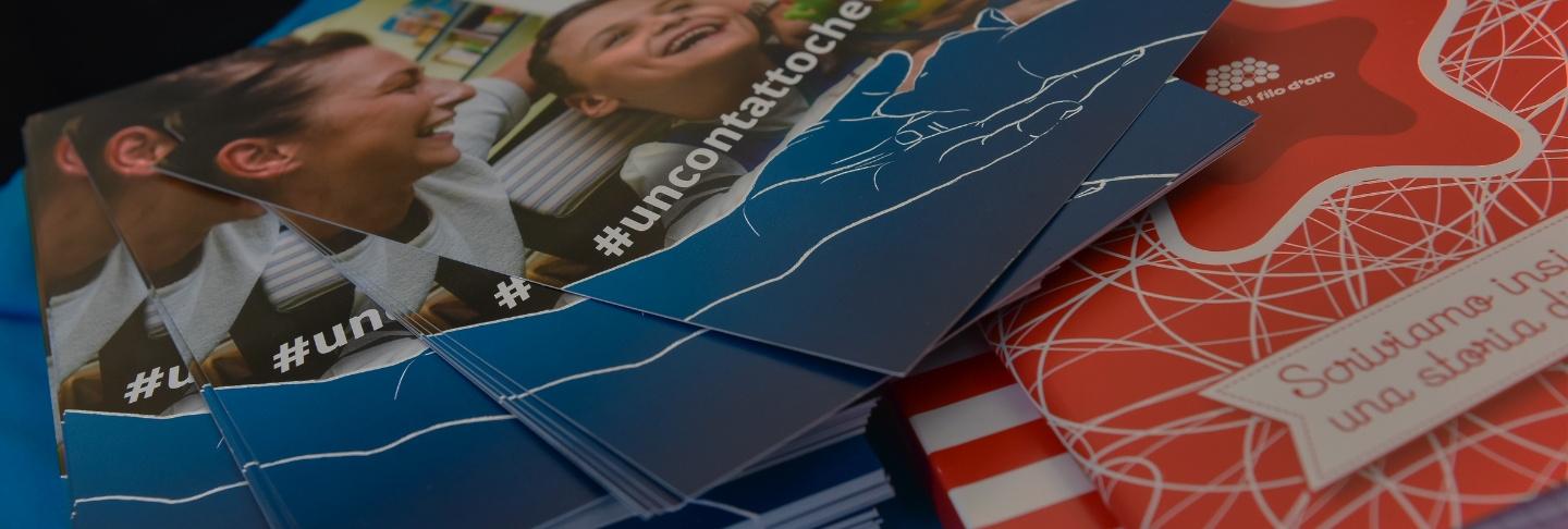 Una serie di volantini della Lega del Filo d'Oro, ciascuno con informazioni e immagini che promuovono le attività e i servizi offerti dall'organizzazione 