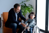 Neri Marcorè tiene la mano di Nicola, che ride e sembra molto entusiasta della presenza di Neri al suo fianco