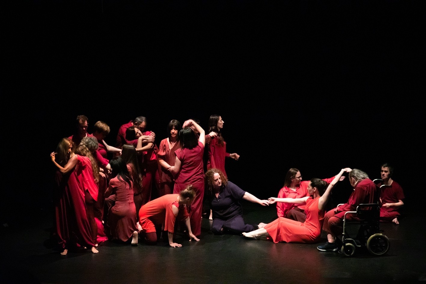 La compagnia Particelle presenta lo spettacolo di danzateatro POV. Su un palco buio, illuminato da luci mirate,il gruppo di performer, formato da operatrici, volontarie e utenti della Sede di Moldetta della Lega del Filo d’Oro. I performer sono vesitit in abiti rossi e creano figure corali.