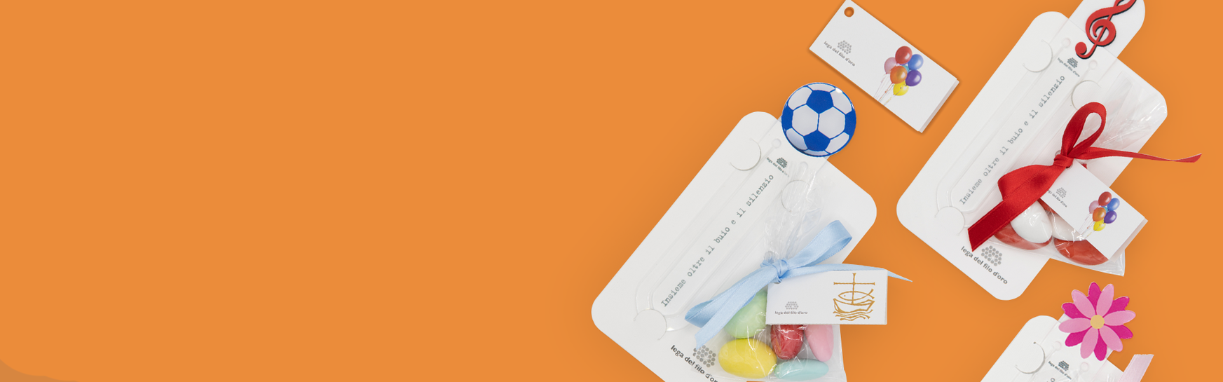 Composizione di bomboniere per cresima su sfondo arancione, con bomboniere a forma di pallone, chiave di violino e fiore, perfette per celebrare questo importante sacramento con eleganza e stile.