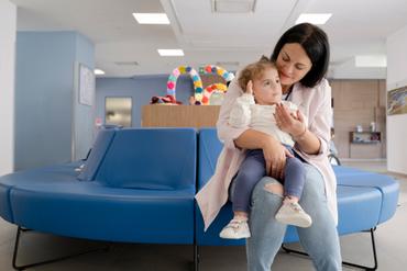 La piccola Benedetta, in braccio a sua mamma Agostina, in un bellissimo abbraccio d'amore sedute nel divanetto dell'ingresso del Centro Nazionale a Osimo