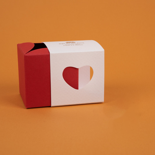 Bomboniera composta da due scatoline in cartoncino pregiato inserite l'una nell'altra. Quella esterna è bianca, quella interna, visibile da un'apertura a forma di cuore, è rossa 46
