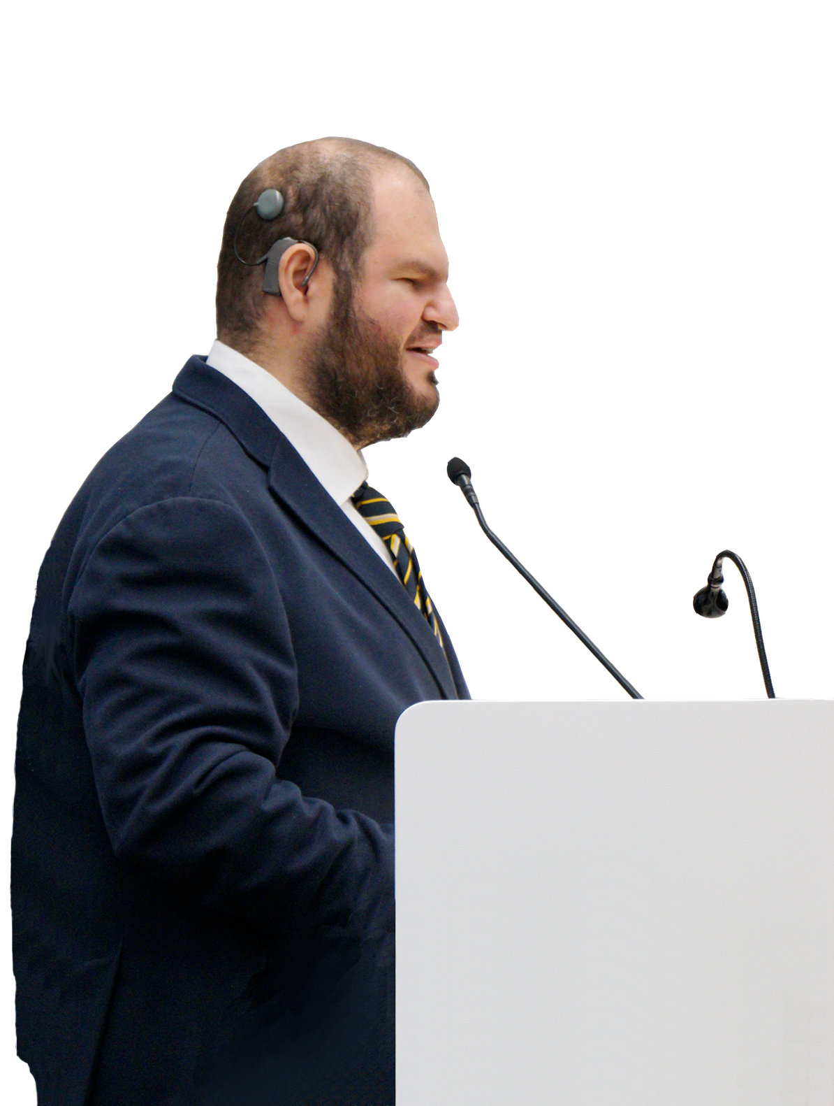 Francesco Mercurio, Presidente del Comitato delle Persone Sordocieche, è in piedi davanti a un piedistallo con due microfoni. È vestito in modo formale.