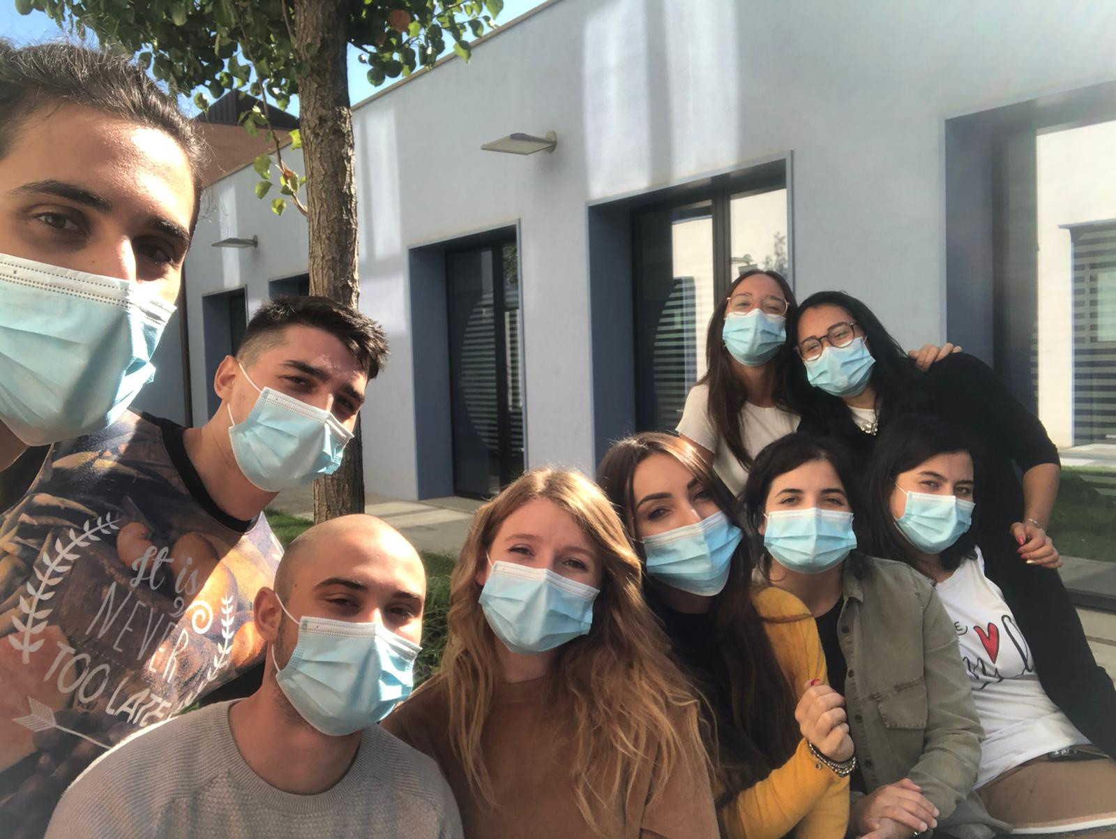 Foto di gruppo di 9 giovani volontari con mascherine chirurgiche
