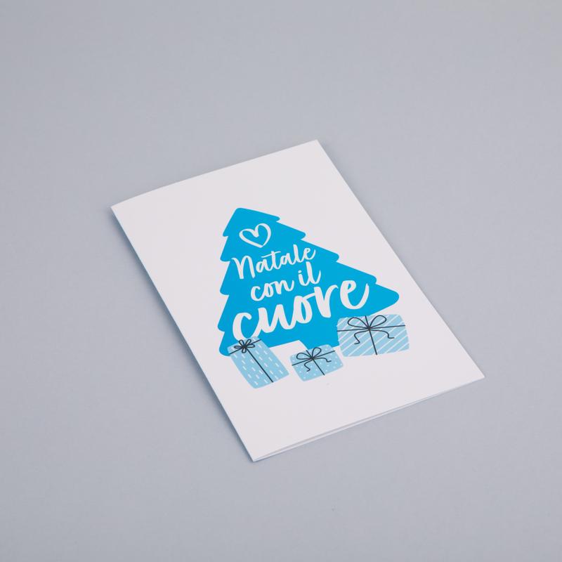 Biglietto di auguri con disegnata la sagoma di un grande albero di Natale azzurro con la scritta "Natale con il cuore" e 3 pacchetti regalo