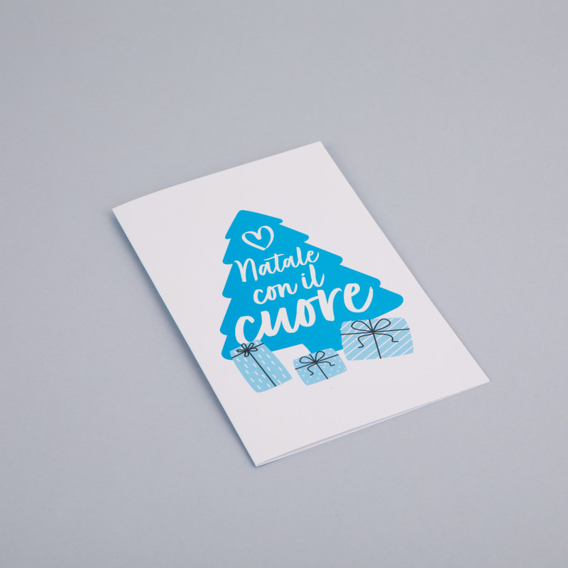 Biglietto di auguri con disegnata la sagoma di un grande albero di Natale azzurro con la scritta "Natale con il cuore" e 3 pacchetti regalo