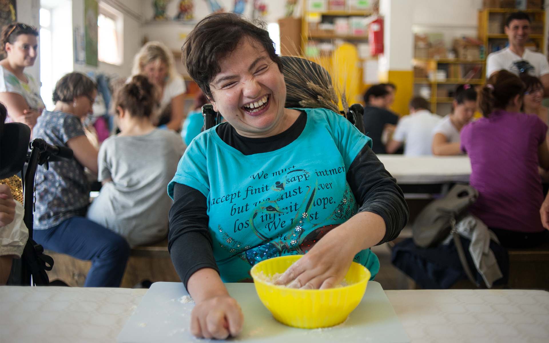La sorridente Paola, ospite residenziale del Centro Nazionale di Osimo, mentre impasta durante un laboratorio