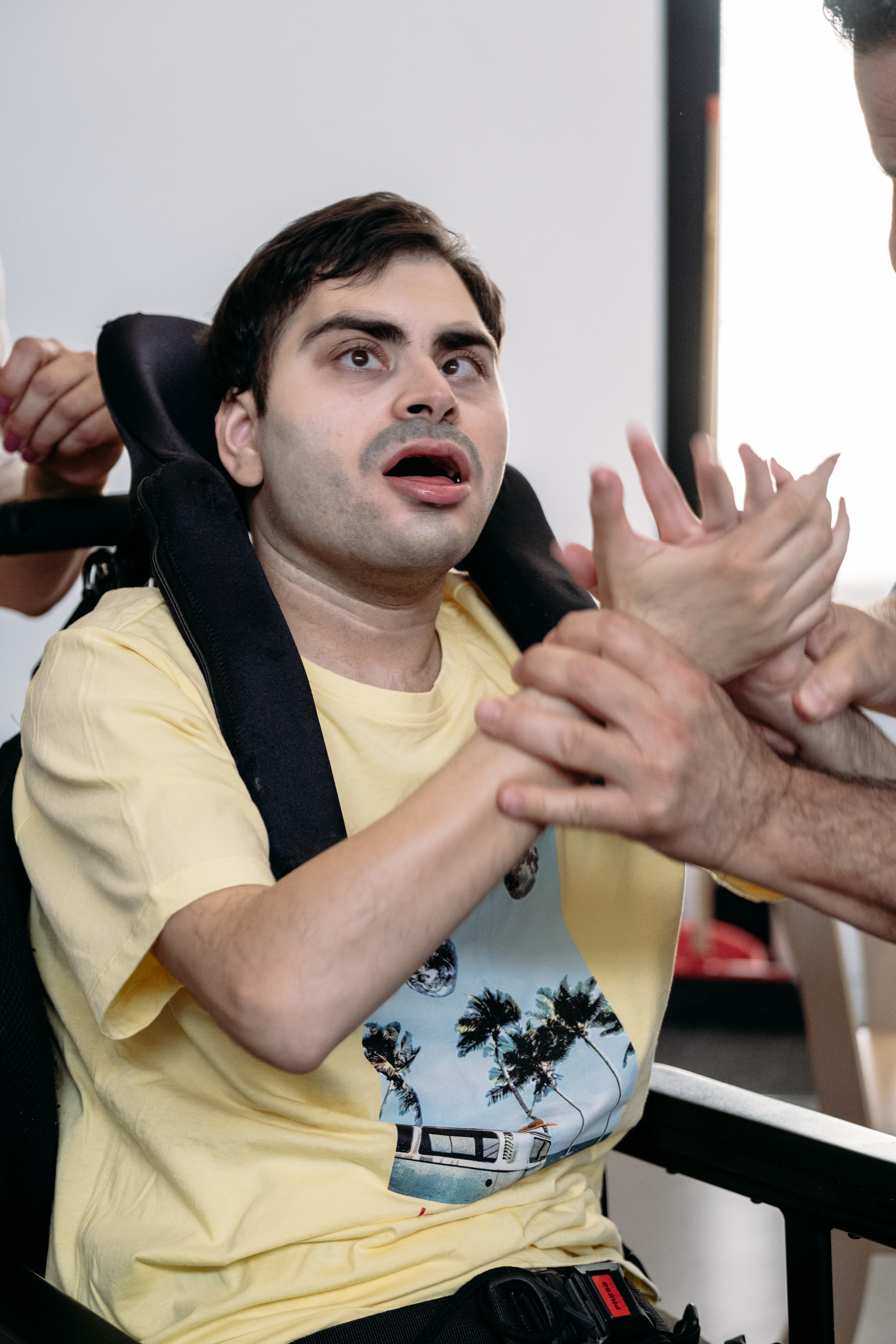 Simone, un utente adulto della Lega del Filo d'Oro, che batte le mani 