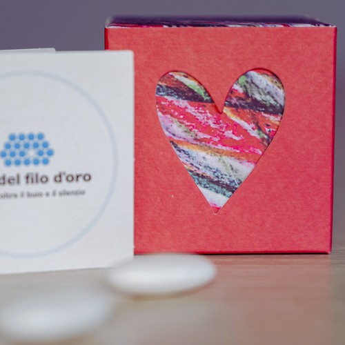 Bomboniera Cubo Pop composta da due scatoline in cartoncino pregiato inserite l'una nell'altra. Quella esterna è Rossa, quella interna, visibile da un'apertura a forma di cuore, ha una fantasia multicolore ispirata ai disegni degli ospiti della Lega del Filo d'Oro 14
