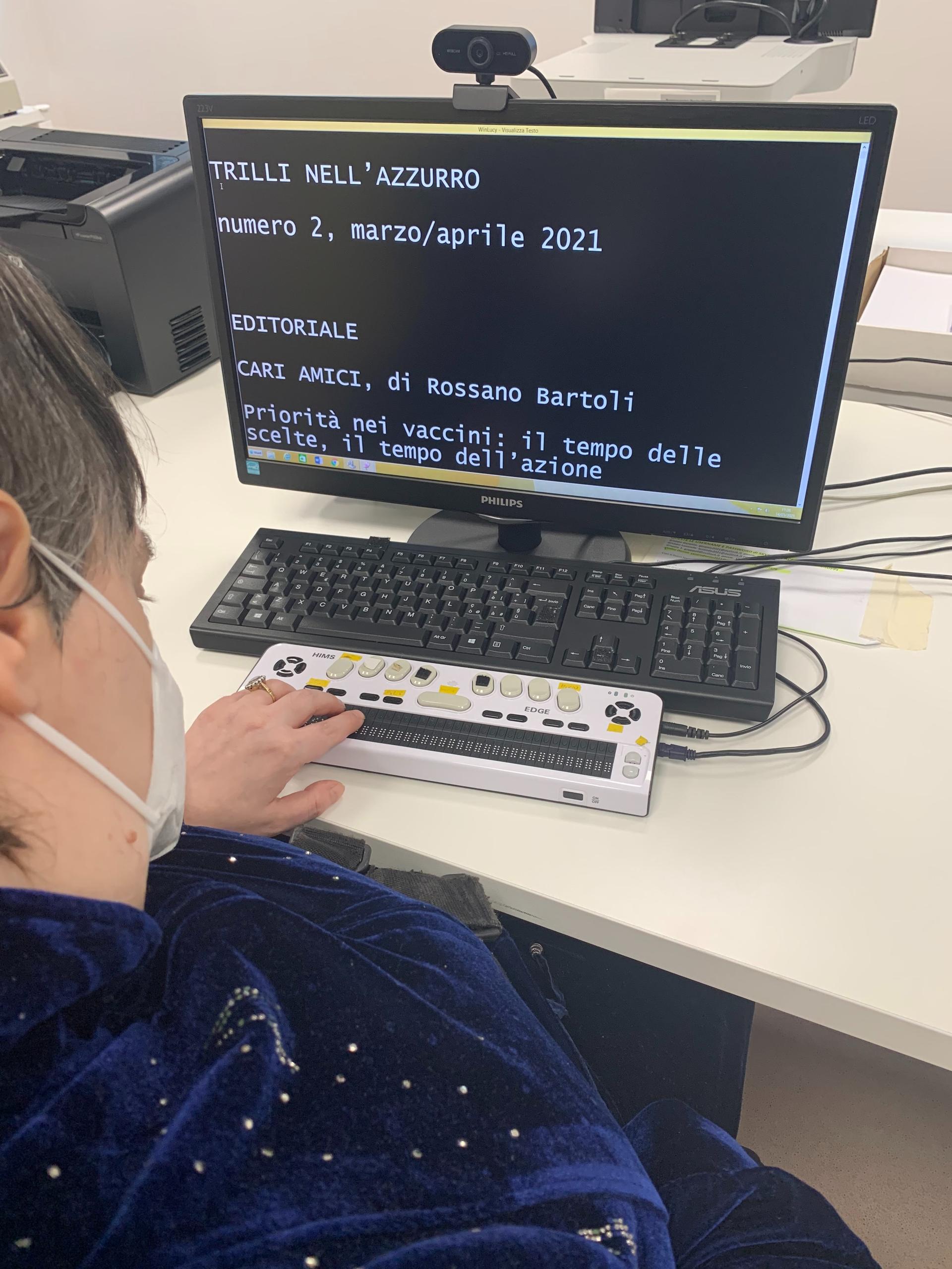 Un utente siede ad un tavolo e utilizza un computer e un altro strumento per accedere alla piattaforma Win Lucy, di cui vediamo alcune scritte sulle schermo. 